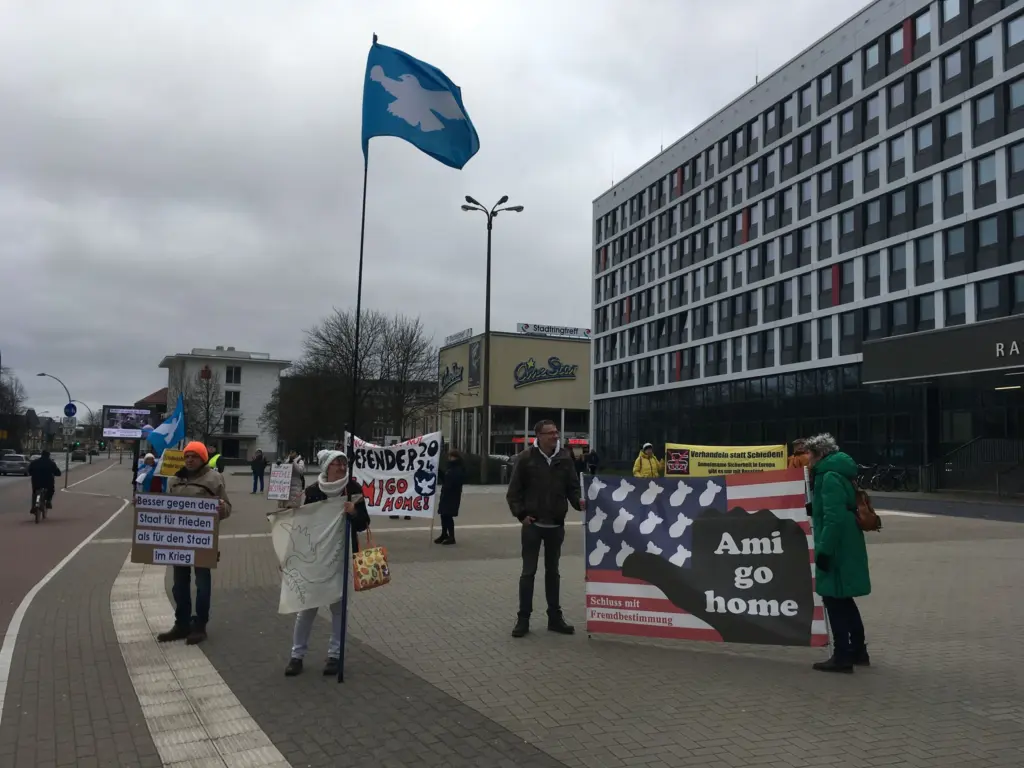 Das Friedensbündnis Neubrandenburg demonstriert anlässlich der Sicherheitskonferenz in München vor dem Neubrandenburger Rathaus mit Schildern. (Foto: Lisa Gutzat)